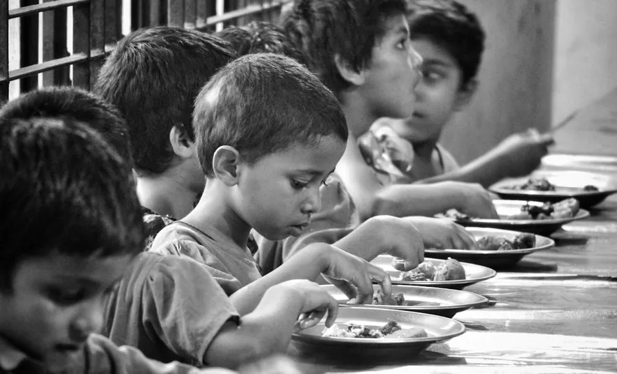 Ilustrasi mimpi anak yatim — boy and girl eating on table