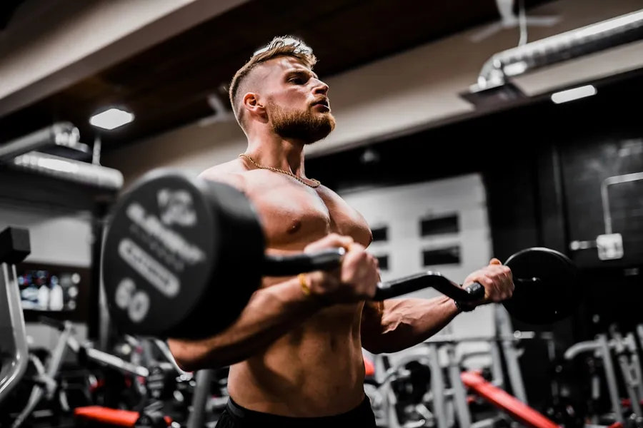 Ilustrasi mimpi angkat besi — topless man in black shorts carrying black dumbbell