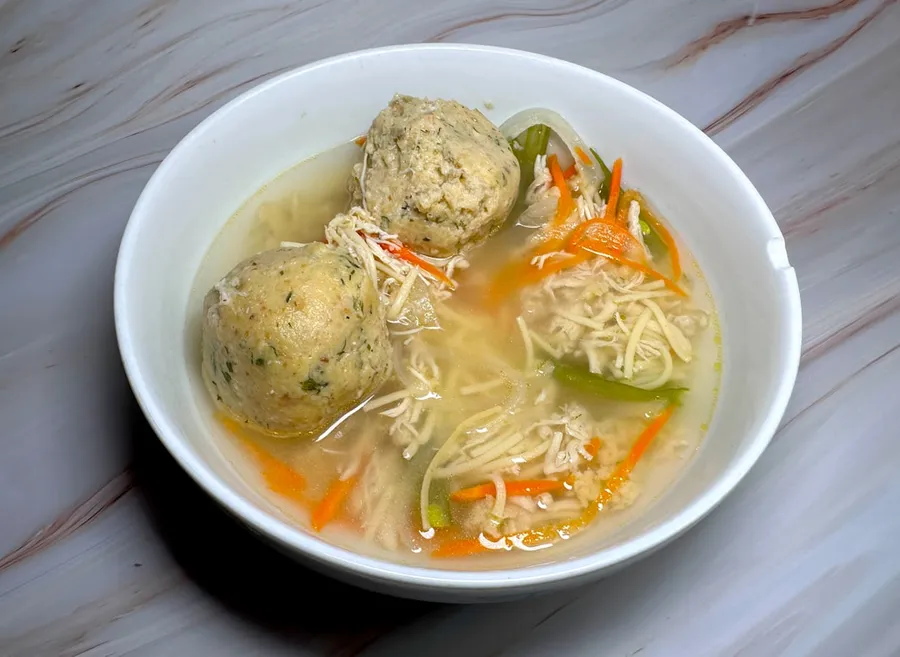 Ilustrasi mimpi bakso — a bowl of soup with meatballs and vegetables