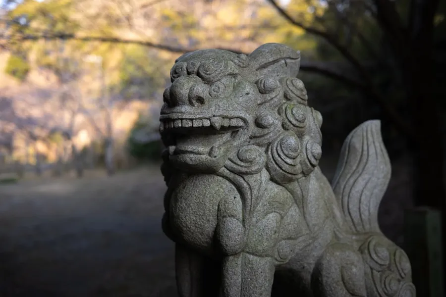 Ilustrasi mimpi dewa maut — Stone lion statue guarding a temple entrance