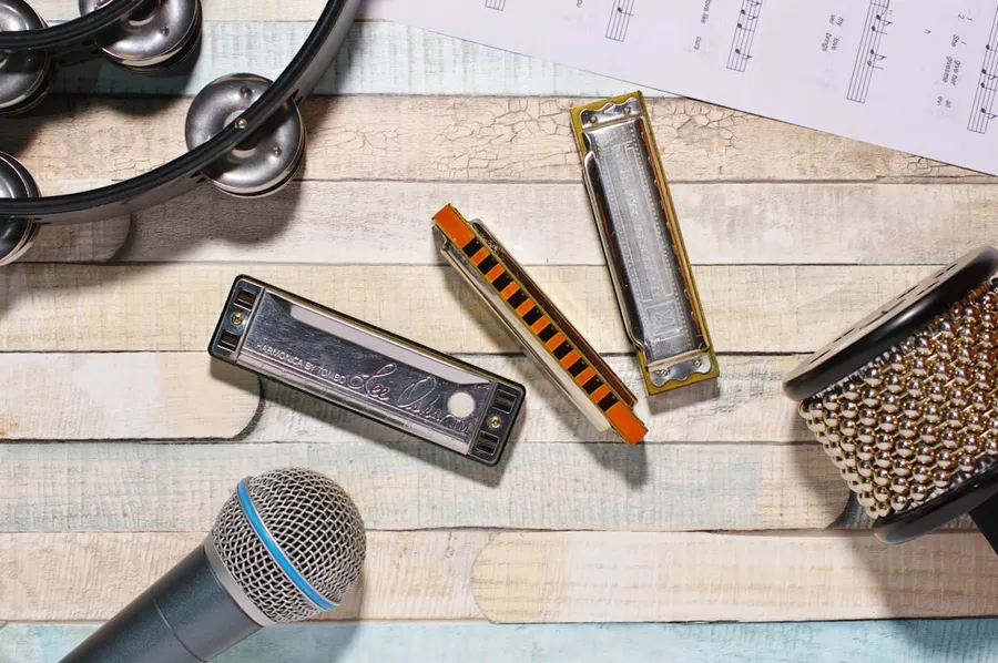 Ilustrasi mimpi harmonika — a table with a microphone, a hair dryer, a comb, and a