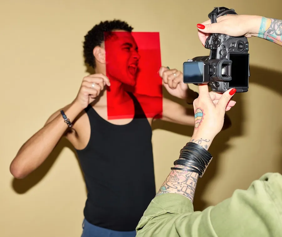 Ilustrasi mimpi kamera — Man's face through red filter, being photographed by camera.