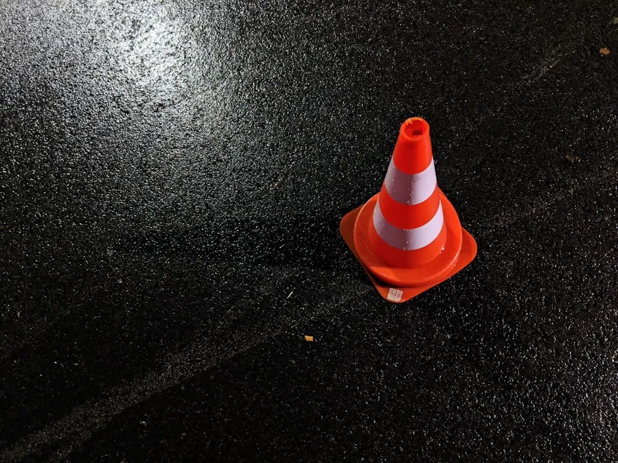 Ilustrasi mimpi kecelakaan — orange and white traffic cone