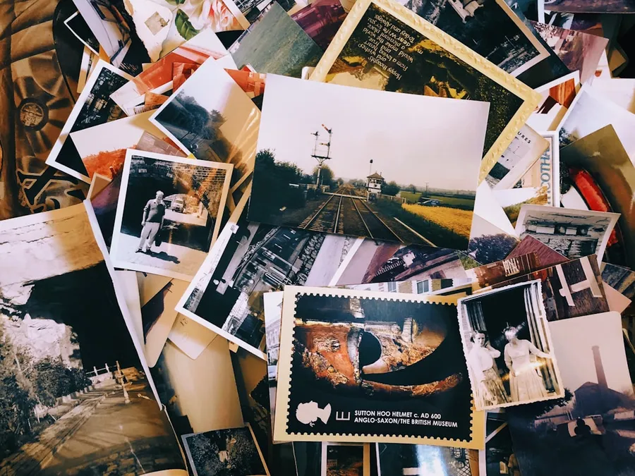 Ilustrasi mimpi mantan — a pile of old photos and postcards sitting on top of each other