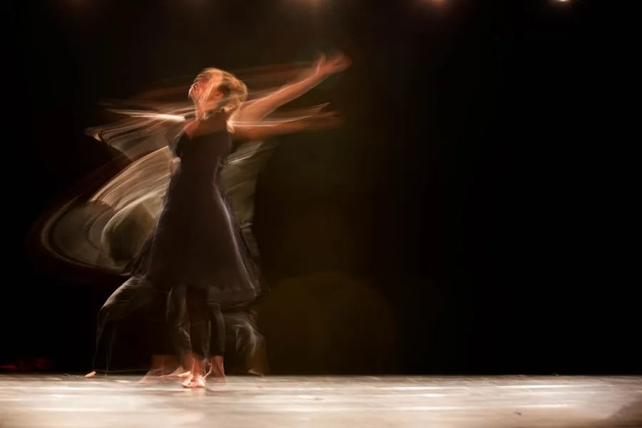 Ilustrasi mimpi menari — a couple of people that are dancing on a stage