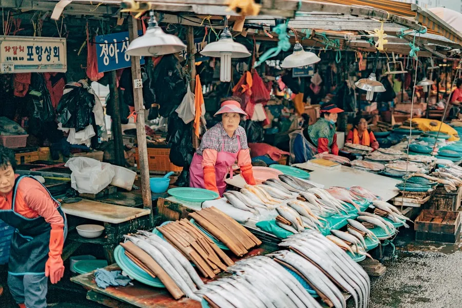 Ilustrasi mimpi pedagang — people sitting on blue and white textile during daytime