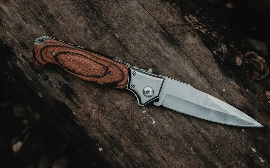 Ilustrasi mimpi pisau — brown handle silver knife on brown wooden table