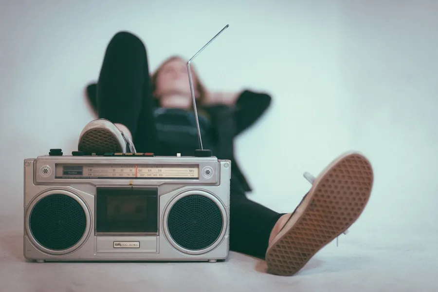 Ilustrasi mimpi radio — woman laying on bed near gray radio