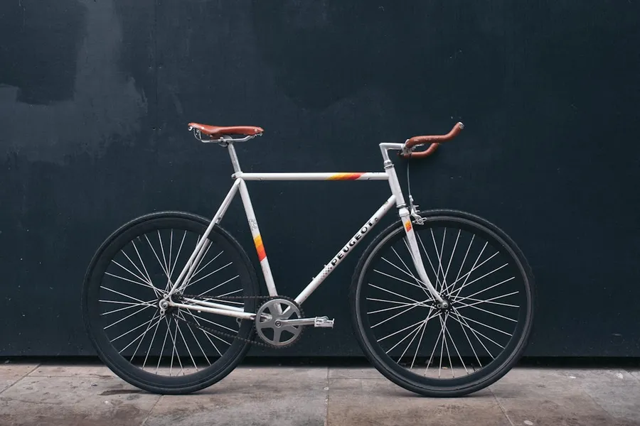 Ilustrasi mimpi sepeda — gray fixie bike leaning on black wall