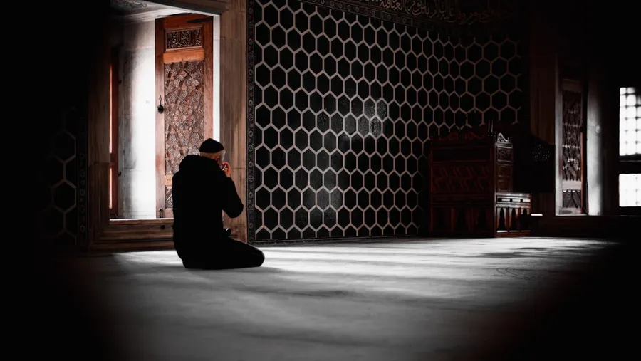 Ilustrasi mimpi sholat — a person sitting in a room