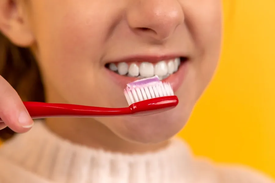 Ilustrasi mimpi sikat — girl with red and white toothbrush in mouth