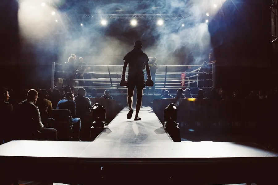 Ilustrasi mimpi tinju — man standing and walking going on boxing ring surrounded with people