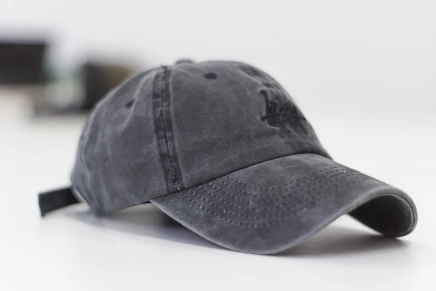 Ilustrasi mimpi topi — gray baseball cap on white surface