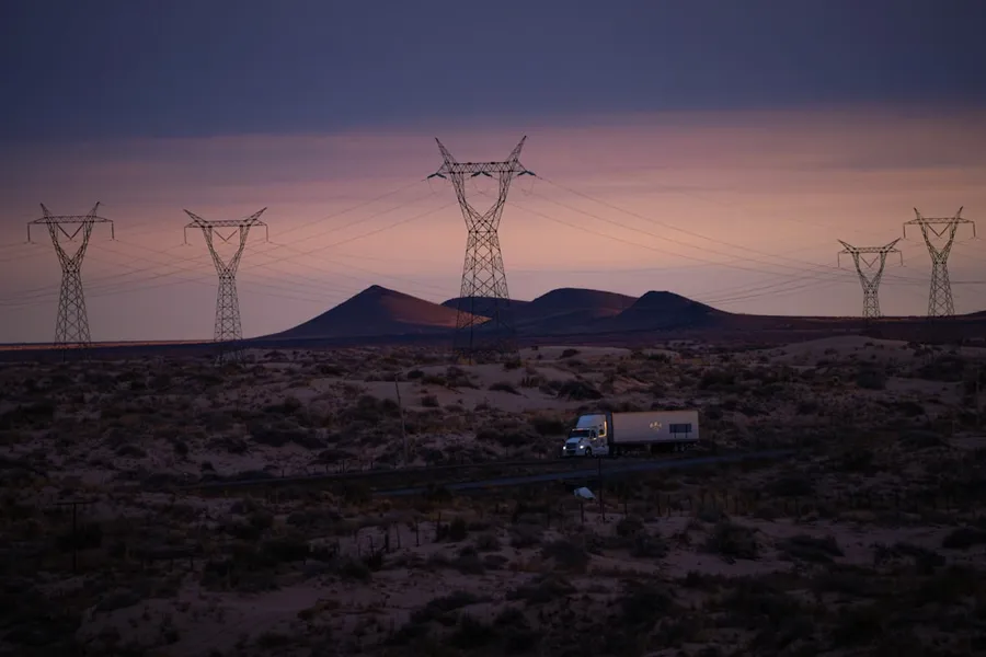 Ilustrasi mimpi truk — Power lines and truck in desolate landscape at dusk